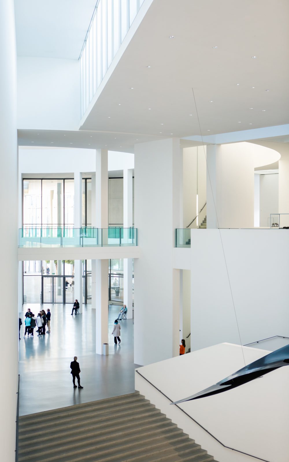 Pinakothek der Moderne Architekturaufnahme. Ein großer heller Raum mit Treppen und Blick auf die Rotunde